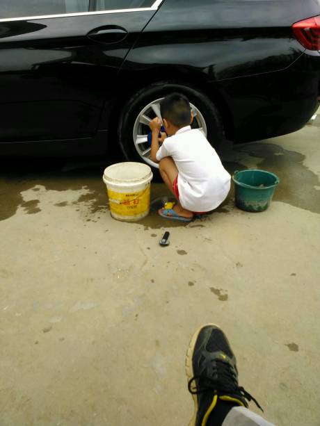 这是老爸翘着腿看孩子给洗车赚学费吗？